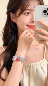 Primer plano de una pulsera de doble hilo de cristal natural rosa y azul en la muñeca