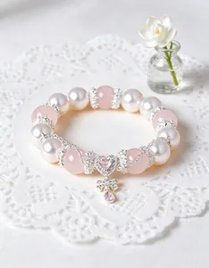 Detalle macro de pulsera de cuarzo rosa natural y perlas con colgante de corazón