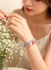 Primer plano de una dulce pulsera de doble capa de cuarzo rosa y cristal azul para mujer