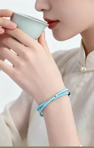 Detalle de una pulsera de cuentas de turquesa y perlas de agua dulce en la muñeca