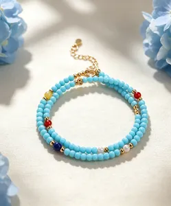 Vista detallada de la pulsera de cuentas turquesas con acentos coloridos y cierre dorado.
