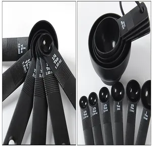 Detailed macro view of black plastic measuring spoons and cups with embossed capacity scales