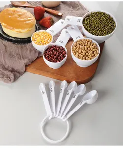 Close-up of white plastic measuring cups and spoons with clear scale markings