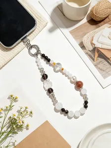 Detail view of white crystal and obsidian beaded phone charm with a carved fox pendant