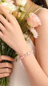 Nahaufnahme eines eleganten Armbands aus rosa Kristallperlen mit Silberanhängern