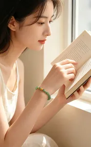 Detailansicht eines eleganten grünen Perlenarmbands mit Goldakzent am Handgelenk
