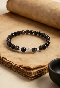 Makroaufnahme eines natürlichen dunklen Steinarmbands mit silbernen Vintage-Perlen.