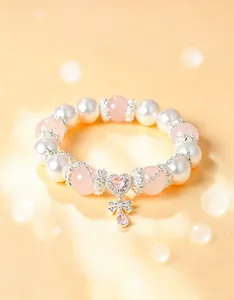 Primer plano detallado de cuarzo rosa natural y perlas blancas con colgante de corazón