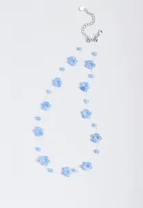 Detail view of blue beaded necklace featuring small flower shapes and adjustable silver clasp.