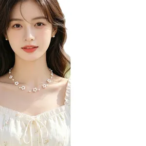 Elegant pearl flower beaded necklace and stud earrings set worn by a model