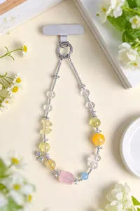 Détail d'une dragonne de téléphone en perles de cristal rose avec charms papillon et cœur