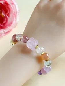 Detail view of multi-color crystal bead bracelet with carved rose quartz on wrist