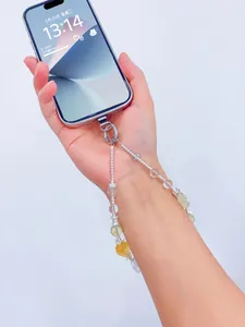 Gros plan d'une dragonne de téléphone en perles de cristal naturel, accessoire de poignet