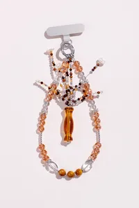 Exquisite Detailansicht eines bernsteinfarbenen Kristallperlen-Phonecharms mit Vasenanhänger.
