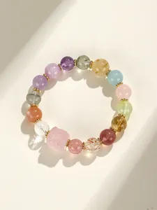 Detailed macro shot of natural multi-colored crystal bead bracelet with rose quartz charm