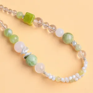 Detailed macro view of natural crystal and green serpentine beaded phone charm