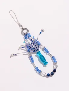 Detailansicht von Lapis-Lazuli- und Kristall-Handyanhänger mit blauem Glasvasenanhänger