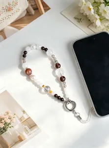 Detail view of crystal beaded phone strap with nine-tailed fox carving and metal ring