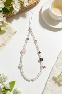 Macro detail of elegant handcrafted phone strap with natural pink and smoky quartz beads