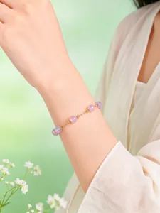 Vista detallada de una delicada pulsera de cuentas de cristal púrpura en la muñeca