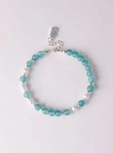Detailansicht des Armbands aus blauem Chalzedon und Perlen mit Segensanhänger.