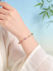 Primer plano de una pulsera de cuentas de cristal natural coloridas en una muñeca femenina