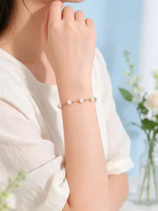 Elegante pulsera de perlas de agua dulce hecha a mano en la muñeca con delicados toques dorados