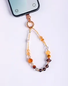 Close-up detail of a handmade phone strap with natural crystal beads and pearls