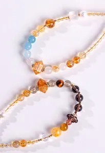 Close-up of crystal phone charms with natural pearls and assorted gemstones
