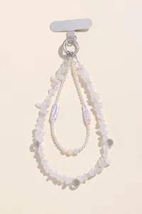 Macro view of aquamarine stone chips and baroque pearls on a handmade beaded charm
