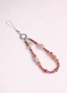Macro detail of natural strawberry quartz beaded phone strap with silver accents
