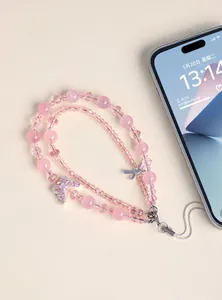 Dettaglio ravvicinato di un cordino per telefono in cristallo rosa a doppio strato con farfalla