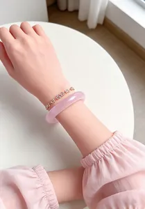 Detail view of elegant pink cat eye stone bangle and crystal flower bracelet set