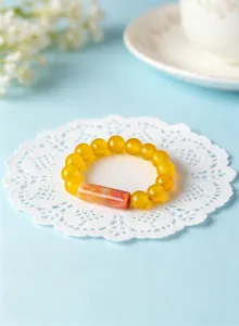 Macro view of a yellow gemstone beaded elastic ring with an orange agate bead centerpiece