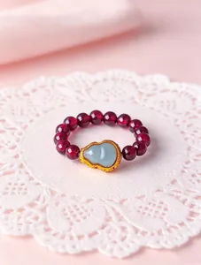 Detailed view of natural red garnet beaded ring featuring a pale green jade gourd