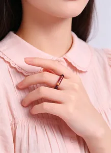 Detail of natural garnet and banded agate beaded elastic ring worn on finger