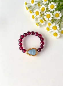 Detailed view of an elegant garnet bead ring with a light blue jade gourd centerpiece