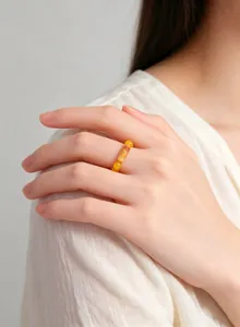 Detailed view of a vintage yellow agate beaded elastic ring worn on a woman's finger