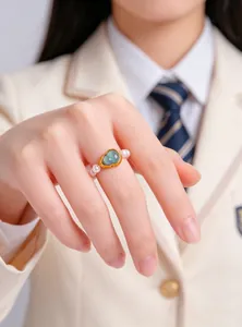 Elegant New Chinese style ring with heart-shaped green stone and pearls worn on a hand