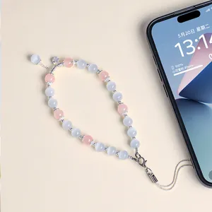 Elegant handmade phone charm with pink and white cat eye beads and small flower pendant