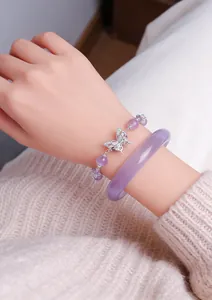 Macro view of lavender amethyst beaded bracelet with butterfly charm and purple bangle set