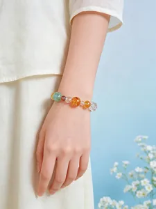 Primer plano de una pulsera de cuentas de cristal natural en la muñeca de una mujer