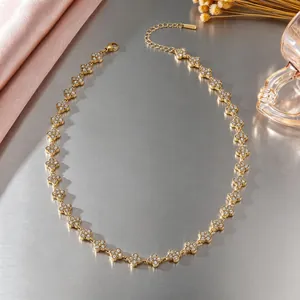 Vue détaillée du collier trèfle en acier doré avec des zircons cubiques scintillants