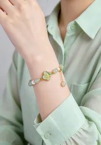 Detailed macro shot of a Chinese style natural green jade and pearl bracelet worn on wrist