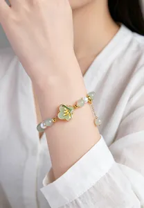 Elegant detail view of a Dongling jade and pearl bracelet worn on a woman's wrist
