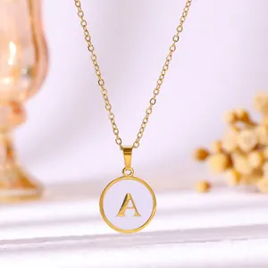 Détail d'un pendentif initial A doré avec émail blanc sur une chaîne en acier inoxydable.