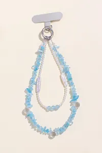 Close-up macro detail of aquamarine and pearl beaded chain charm for phone or bag.