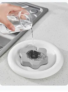 Nahaufnahme von Wasser, das auf einen grauen, blumenförmigen Schwamm in der Spüle fließt.