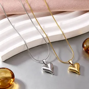 Nahaufnahme von herzförmigen Anhängern in Gold und Silber mit Schlangenketten.