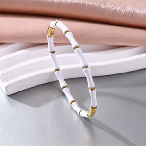 Detailansicht eines eleganten elastischen Armbands mit weißen Emaille- und Gold-Bambussegmenten